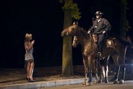 Pomáhat a chránit. Prostitutka a policisté koňmo.