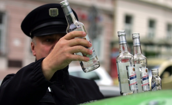 Policista odebírající vzorky z lahve vyrobené Likérkou Drak.