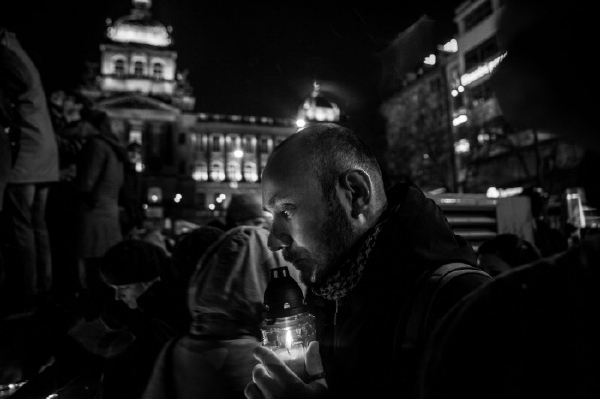 Vítězná černobílá fotografie zachycuje muže, který rozsvěcí svíčku na jednom z pietních míst, jež po smrti Havla spontánně vznikla, na Václavském náměstí v Praze (autor: Milan Jaroš, Respekt).
