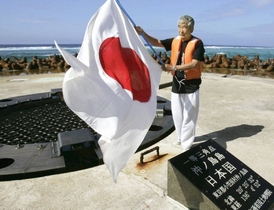 Tokijský guvernér Šintaró Išihara vztyčuje japonskou vlajku na sporném ostrově.