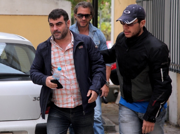 Kostas Vaxevanis (vlevo) odváděn policisty v civilu. Kostas Vaxevanis (vlevo) odváděn policisty v civilu.