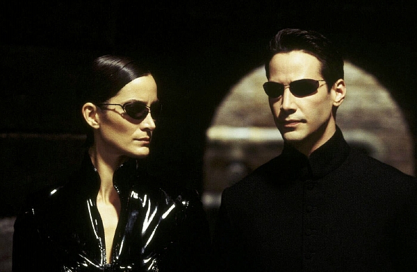 Carrie-Anne Mossová jako Trinity a Keanu Reeves jako Neo v dnes už klasickém sci-fi Matrix. Carrie-Anne Mossová jako Trinity a Keanu Reeves jako Neo v dnes už klasickém sci-fi Matrix.