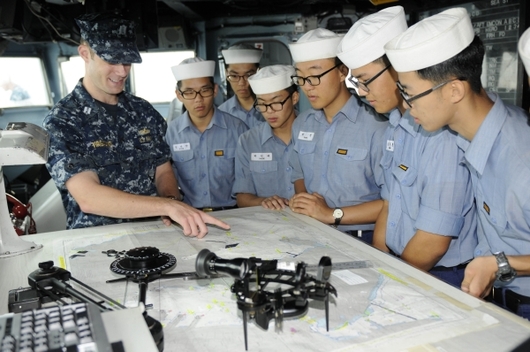 Jihokorejští námořníci na návštěvě na kapitánském můstku USS Guardian.