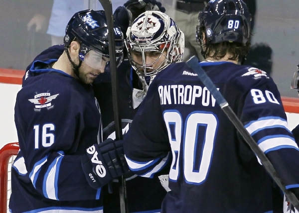Ondřej Pavelec (uprostřed) a jeho spoluhráči  Andrew Ladd  (vlevo) a Nik Antropov (vpravo).