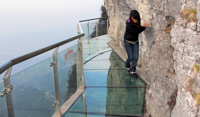 Ve východní Číně se nachází hora Tianmen, kterou ve výšce 1430 metrů obepíná 60 metrů dlouhý, místy skleněný chodník. Není divu, že někteří návštěvníci jsou si při chůzi po něm tak nejistí, že se raději drží u okraje. Nevyzkoušet si tohle jedinečné dobrodružství je ale příliš velkým pokušením. Chodník je široký necelý metr, přičemž tloušťka skleněné podlahy je pouhých 6,3 centimetrů. Šílené? Souhlasíme. Třešničkou na dortu je, že návštěvníci musejí mít boty obalené hadrem, aby průhledné sklo příliš nepošpinili a nezkazili tak výhled ostatním. (Foto: ČTK) Ve východní Číně se nachází hora Tianmen, kterou ve výšce 1430 metrů obepíná 60 metrů dlouhý, místy skleněný chodník. Není divu, že někteří návštěvníci jsou si při chůzi po něm tak nejistí, že se raději drží u okraje. Nevyzkoušet si tohle jedinečné dobrodružství je ale příliš velkým pokušením. Chodník je široký necelý metr, přičemž tloušťka skleněné podlahy je pouhých 6,3 centimetrů. Šílené? Souhlasíme. Třešničkou na dortu je, že návštěvníci musejí mít boty obalené hadrem, aby průhledné sklo příliš nepošpinili a nezkazili tak výhled ostatním. (Foto: ČTK)