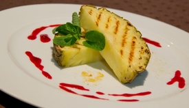 Pečený ananas s mátou a malinovým coulis.