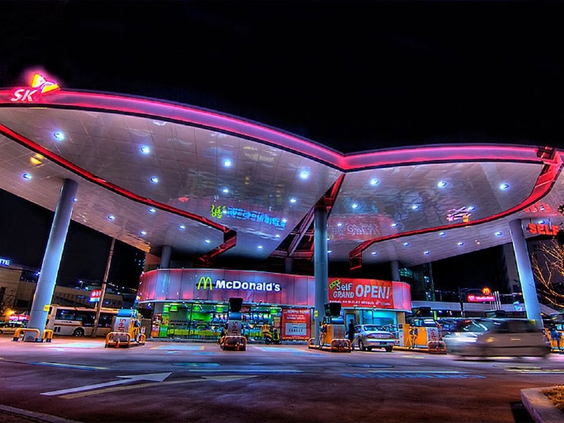 Ulsan (Jižní Korea). Barevná malá benzínová pumpa nabízí kromě natankování zákazníkům i možnost zajet si k okénku fastfoodu a vzít si jídlo s sebou. Ulsan (Jižní Korea). Barevná malá benzínová pumpa nabízí kromě natankování zákazníkům i možnost zajet si k okénku fastfoodu a vzít si jídlo s sebou.