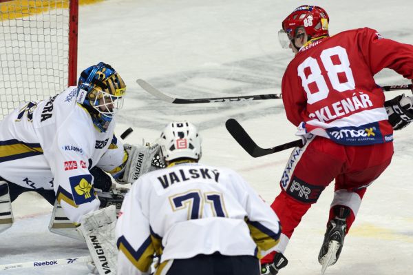 Jakub Sklenář z HC Slavia Praha (vpravo) ohrožuje kladenského brankáře Jana Cháberu, uprostřed kladenský Jakub Valský.