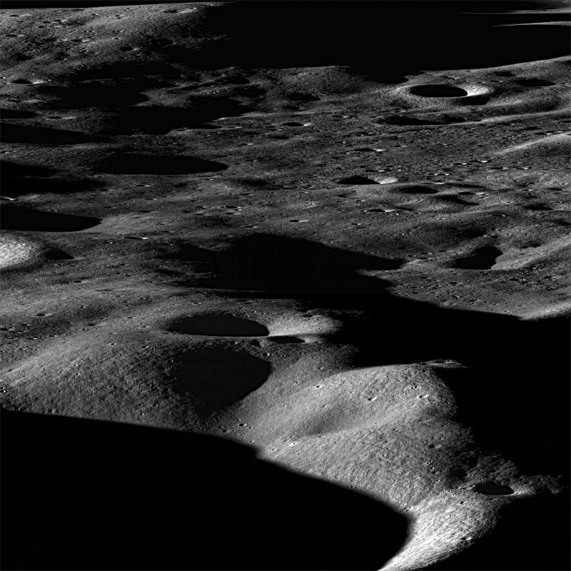 Měsíční kráter pokrytý prachem, jak ho vyfotografovala sonda Lunar Reconnaissance Orbiter.