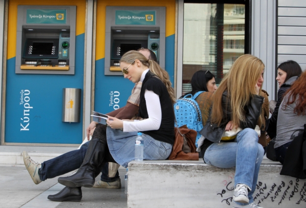 Desítky lidí obléhají bankomaty, aby si ještě vybrali několik bankovek. Desítky lidí obléhají bankomaty, aby si ještě vybrali několik bankovek.