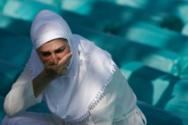 Bosenská žena truchlí mezi rakvemi s exhumovanými těly tisíců muslimských obětí - chlapců a mužů.