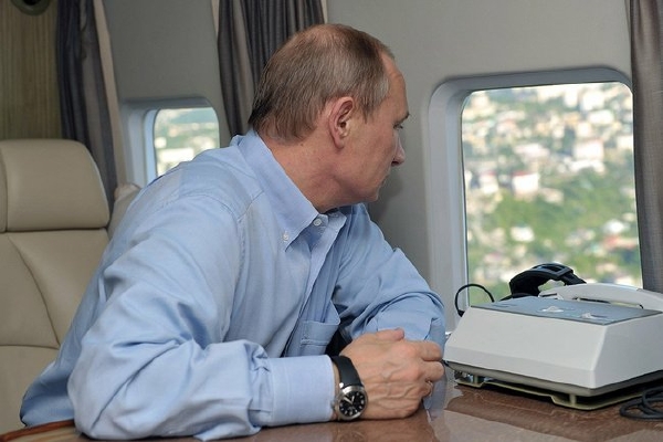 Putin se dívá z okna za letu ve svém vrtulníku.