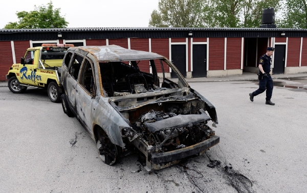 Policie odklízí shořelá auta.