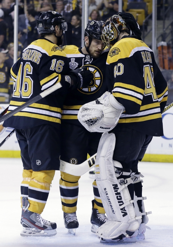 Boston Bruins left wing Kaspars Daugavins (16), of Latavia, and defenseman Andrew Ference, center, congratulate Boston Bruins goalie Tuukka Rask (40)