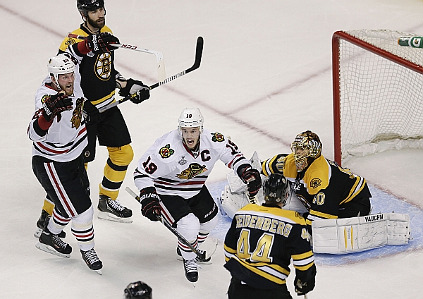 Bryan Bickell a Jonathan Toews se radují z vítězného gólu Brenta Seabrooka (mimo snímek), který zpečetil vítězství Chicago Blackhawks nad Boston Bruins.