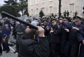 Demonstrant útočí na albánské policisty.