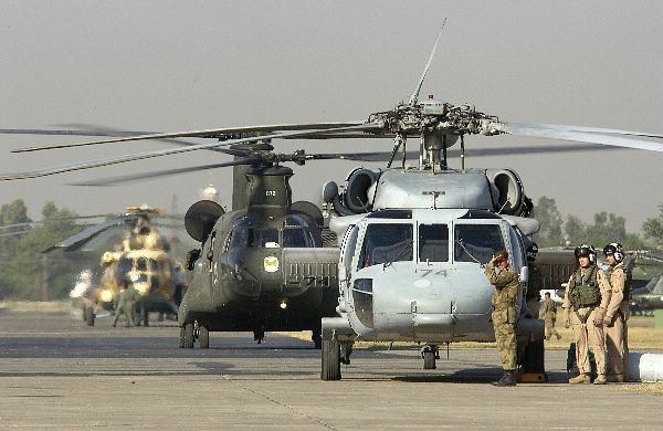 V řadě za sebou stojí vrtulníky SH-60 Sea Hawk, CH-47 Chinook a Mi-17.