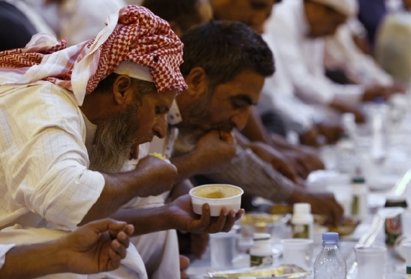 Muslimští dělníci v Rijádu se při ramadánu krmí večer po půstu.