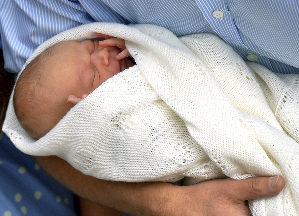Britský princ George Alexander Louis v náručí svého otce Williama. Britský princ George Alexander Louis v náručí svého otce Williama.
