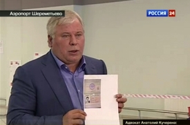 Snowdenův právník Anatolij Kučerena s dokumentem opravňujícím whistleblowera opustit moskevské letiště Šeremeťjevo.