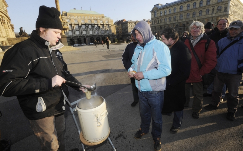 Pracovníci charitativní společnosti Naděje rozlévají na Alšově nábřeží v Praze lidem bez přístřeší polévku a teplý čaj.