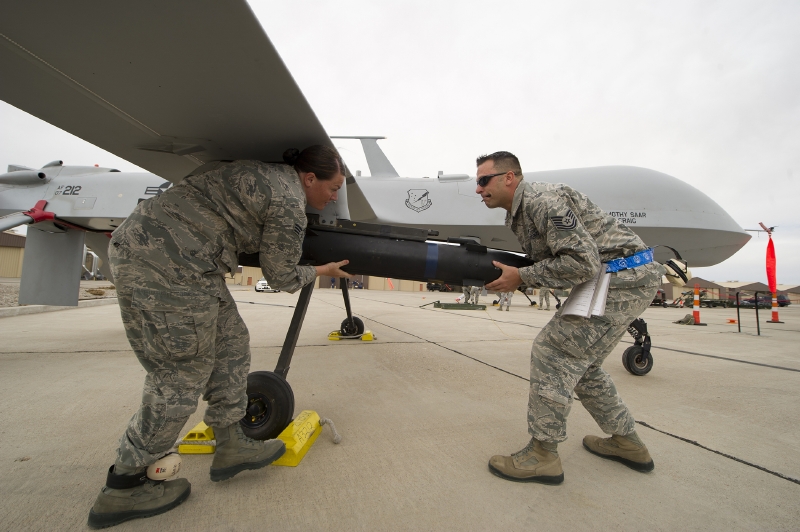 Američtí vojáci vyzbrojují dron raketou.