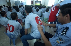 V pracovním táboře u Pekingu sledují sportovní přenos.