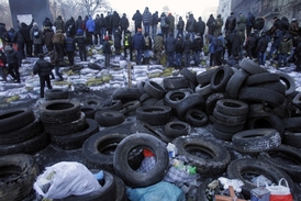 Protestující hlídají barikádu před policií.