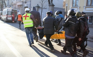 Odnášejí zraněného policistu po střetech s radikály.