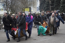 Demonstranti odnášejí zraněné.