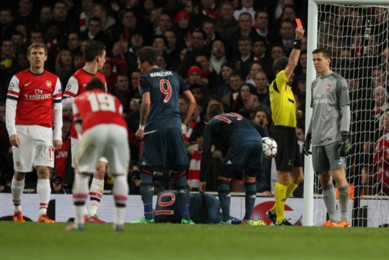 Brankář Arsenalu Szczesný dostává v duelu s Bayernem červenou kartu za faul na Robbena.