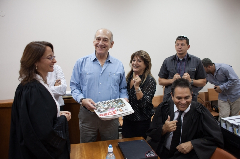 Expremiér Olmert (modrá košile) u soudu se svými právníky a bývalou sekretářkou (po jeho levém boku).