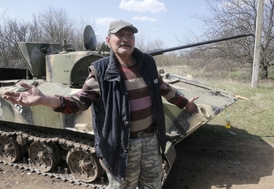 Ukrajinské jednotky o víkendu pozastaví "aktivní fázi protiteroristické operace". Místní jsou v klidu i tak. Na snímku obyvatel vsi nedaleko Kramatorsku a zničený obrněnec ukrajinské armády.