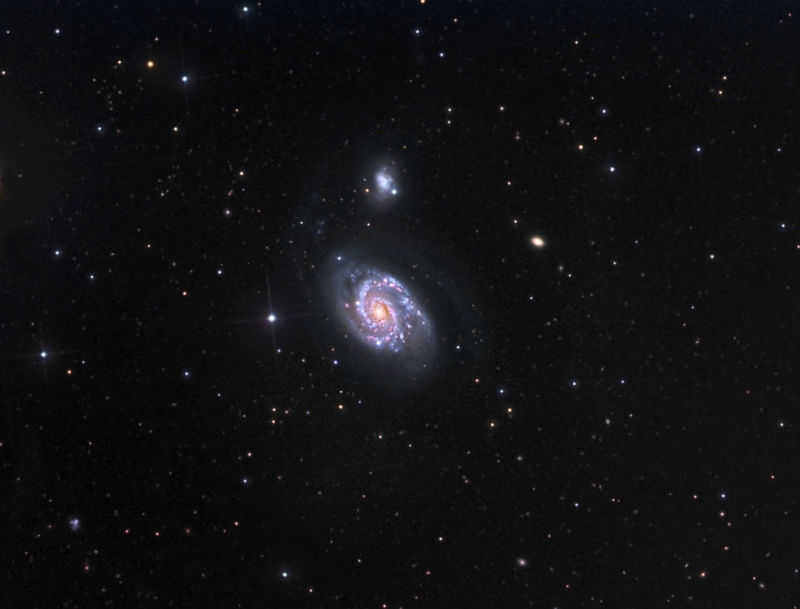 Menší galaxie na obrázku se časem srazí s větší.