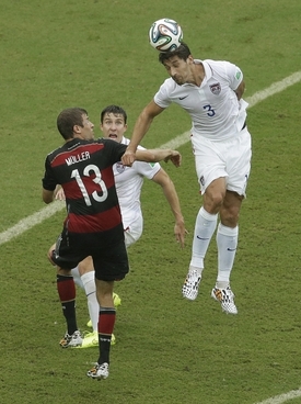 Německý střelec Thomas Müller (vlevo) v souboji s obránci USA.