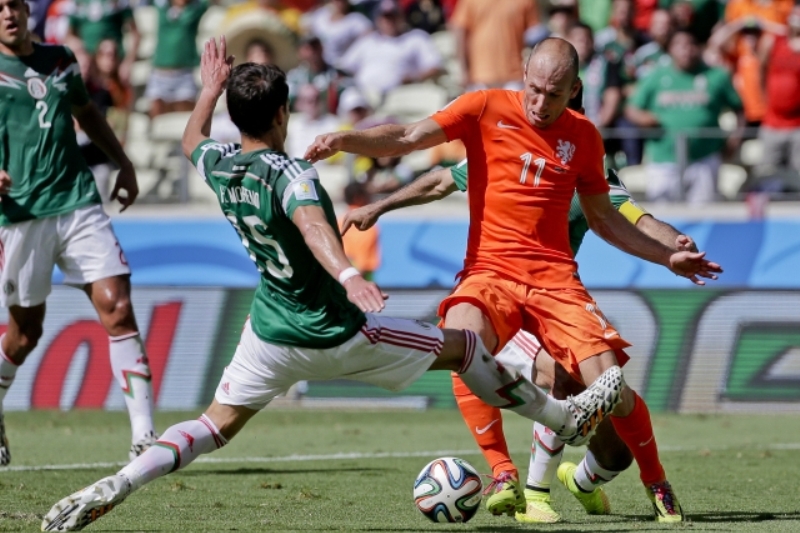 Hvězda Nizozemska Arjen Robben (vlevo) se probíjí mexickou obranou.