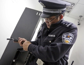 Policista si před službou kontroluje zbraň.
