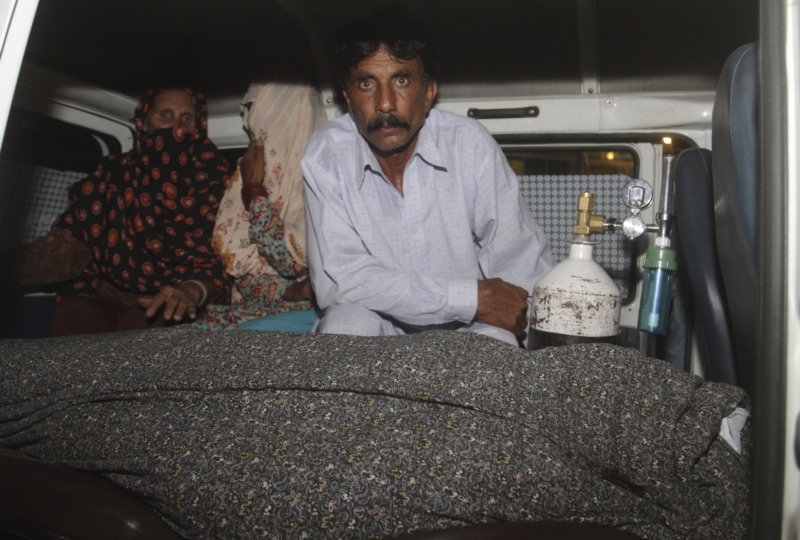 Mohammad Ikbal sedí v ambulanci vedle těla své těhotné, ukamenované ženy. Mohammad Ikbal sedí v ambulanci vedle těla své těhotné, ukamenované ženy.