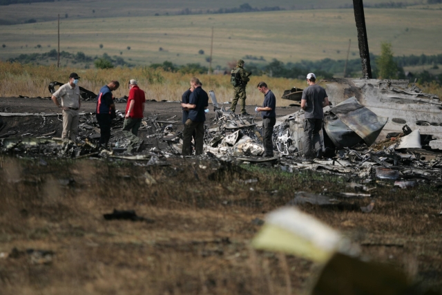 Lidé mezi troskami zříceného boeingu na Ukrajině.