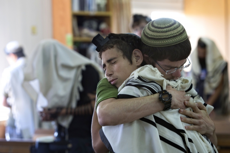 Izraelští studenti se objímají před modlitbou v synagoze, kde dva z unesených mladíků studovali. Izraelští studenti se objímají před modlitbou v synagoze, kde dva z unesených mladíků studovali.