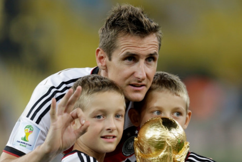 Miroslav Klose se svými syny s trofejí pro mistra světa.