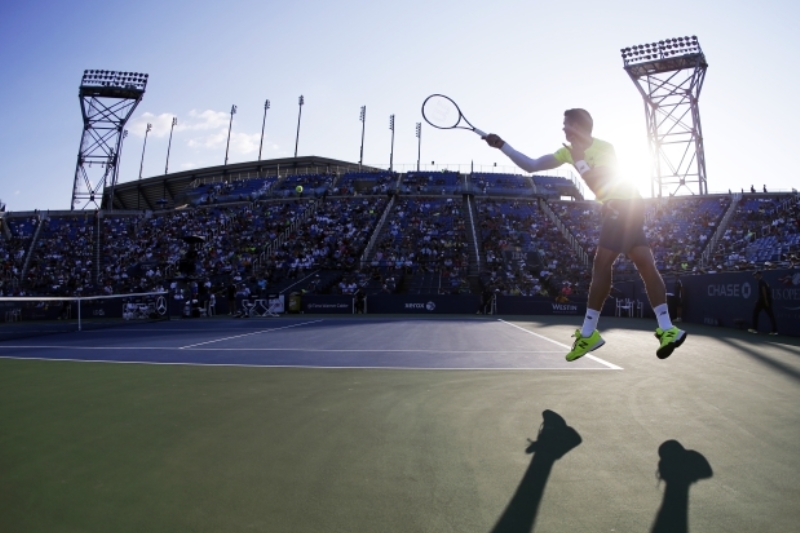 Fotografové se během US Open vyřádí. Takhle parádně třeba zachytili Kanaďana Milose Raoniče v utkání s Japoncem Taro Danielem. (ČTK/AP/Darron Cummings)