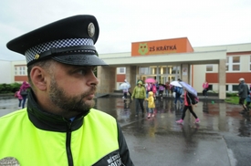 Policista hlídkuje u základní školy v Klášterci nad Ohří.
