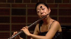 Japonská flétnistka se nenechala rozhodit a skladbu dohrála.