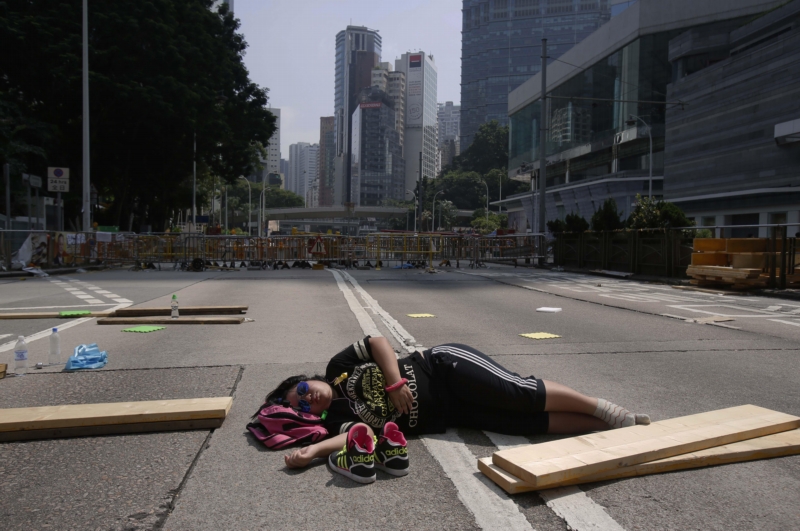Jeden z protestujících studentů spí uprostřed ulice v Hongkongu.