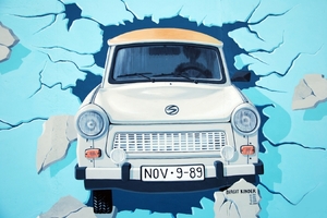 Trabant projíždí Berlínskou zdí v den jejího pádu (viz SPZ). Malba na části zdi zvané Eastside Gallery.