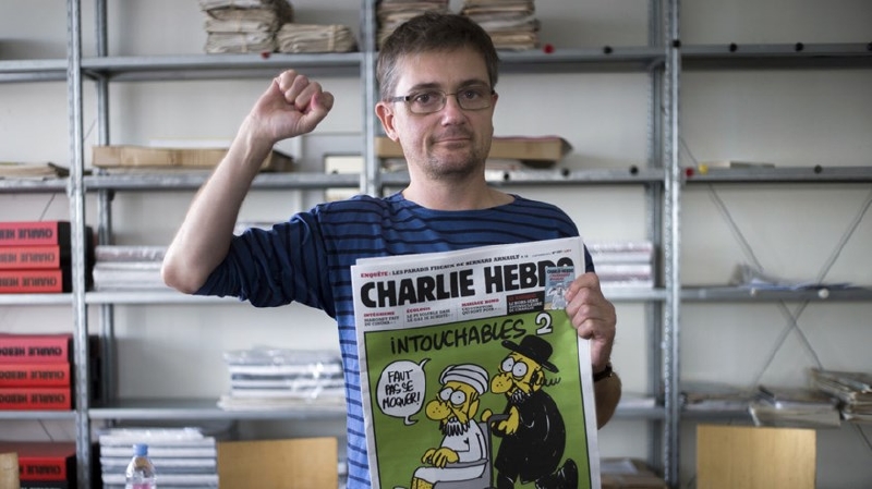 Vydavatel francouzského satirického týdeníku Charlie Hebdo, známý jen jako Charb, ukazuje číslo časopisu na kterém je karikatura Mohameda.