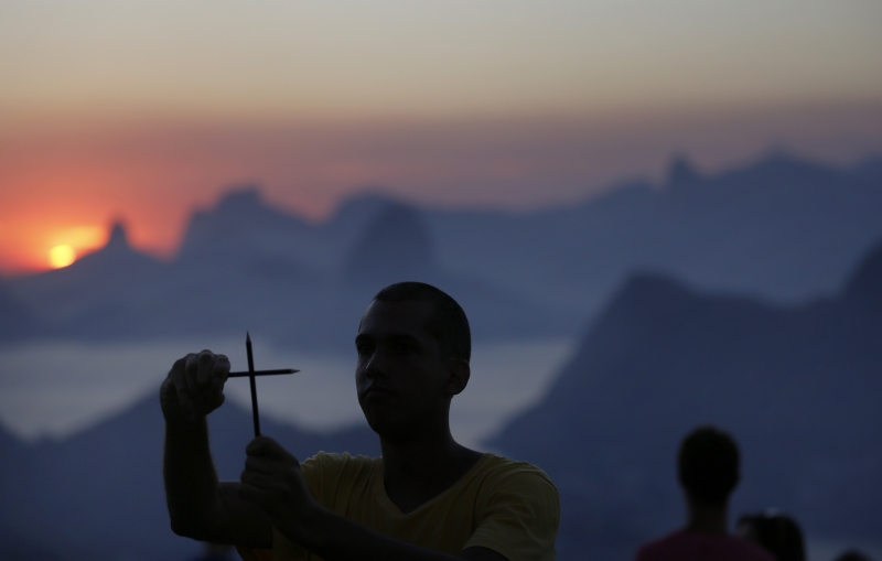 Muž v Brazílii znázorňuje dvěma tužkama křiž. Uctívá tak památku redakce Charlie Hebdo. Muž v Brazílii znázorňuje dvěma tužkama křiž. Uctívá tak památku redakce Charlie Hebdo.