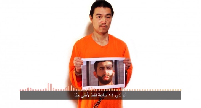 Japonský zajatec islamistů Goto s fotografií jordánského pilota.