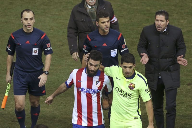Všichni zúčastnění. Dvojice rozhodčích, vlevo od nich trenér Atlétika Diego Simeone a před nimi Arda Turan (vlevo) s útočníkem Barcelony Louisem Suárezem. 